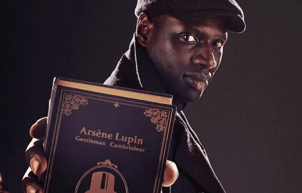 Photo of Omar Sy with a book of Arsène Lupin